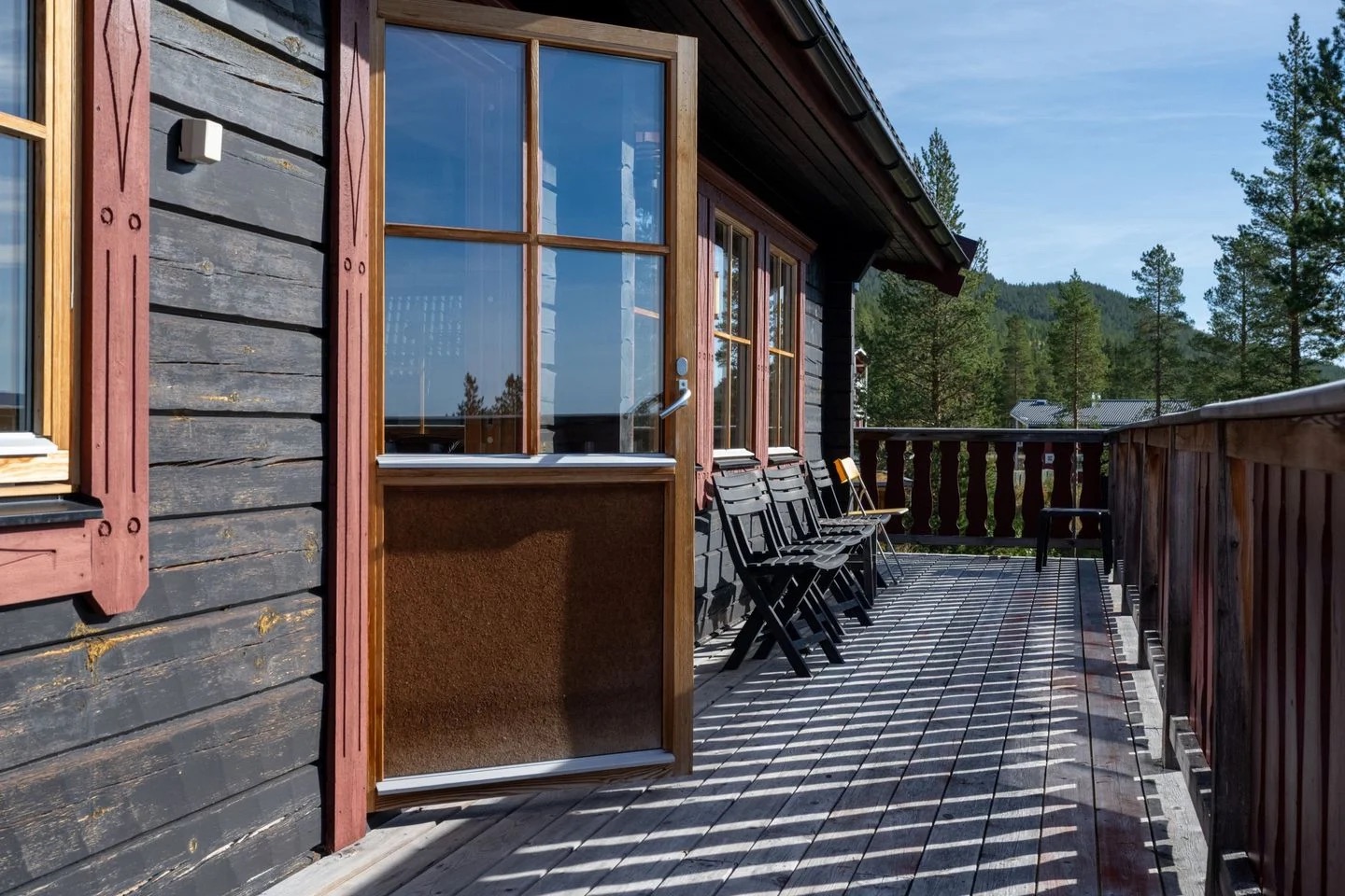 Altan med utemöbler och utsikt över fjällskogen
